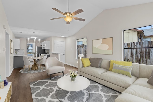 living room featuring ceiling fan with notable chandelier, sink, vaulted ceiling, and dark hardwood / wood-style floors