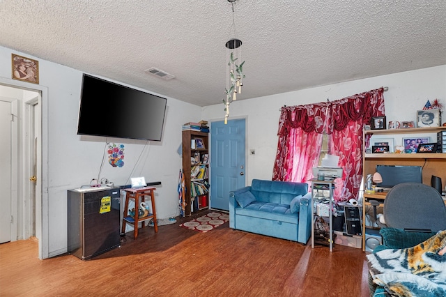 living room featuring a textured ceiling and hardwood / wood-style flooring