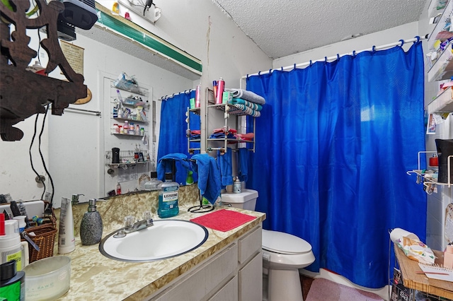 bathroom with toilet, vanity, and a textured ceiling