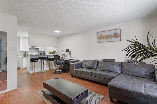 living room with wood-type flooring and a textured ceiling