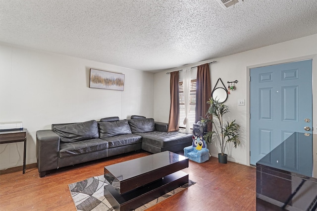 living room with hardwood / wood-style flooring and a textured ceiling