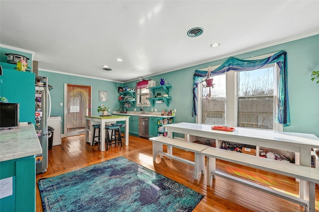 dining space with wood-type flooring and ornamental molding