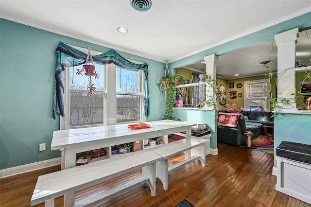 dining room featuring ornamental molding, dark hardwood / wood-style floors, and decorative columns