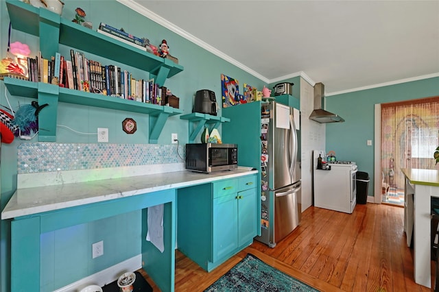 kitchen featuring stainless steel appliances, crown molding, wall chimney range hood, and blue cabinets