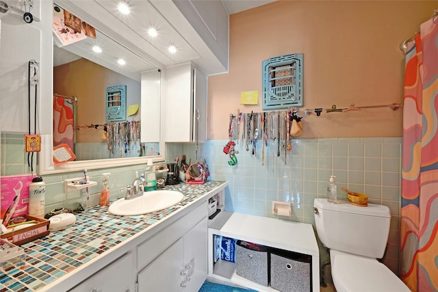 bathroom with vanity, toilet, and tile walls