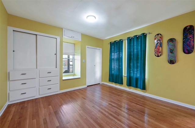 unfurnished bedroom with light wood-type flooring and a closet