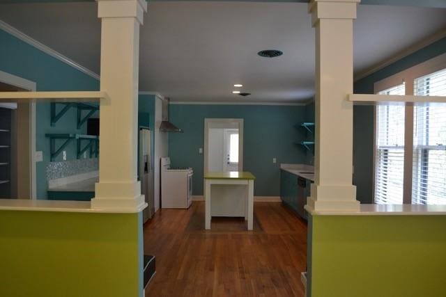 kitchen featuring crown molding, decorative columns, and range