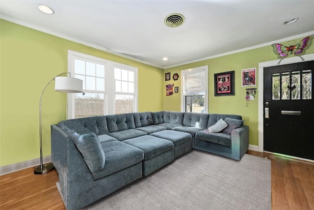 living room with crown molding, a healthy amount of sunlight, and wood-type flooring