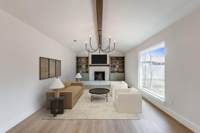 living room featuring light hardwood / wood-style flooring, an inviting chandelier, and a wealth of natural light