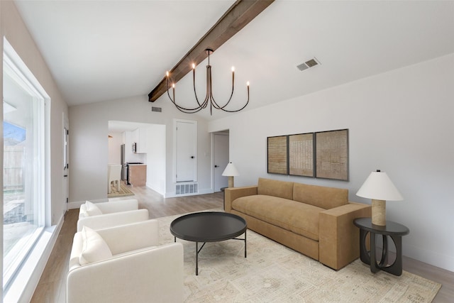 living room with an inviting chandelier, lofted ceiling with beams, and light hardwood / wood-style flooring