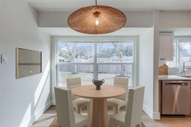 dining area with sink and light hardwood / wood-style flooring