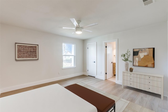 bedroom with ceiling fan, light wood-type flooring, and ensuite bathroom