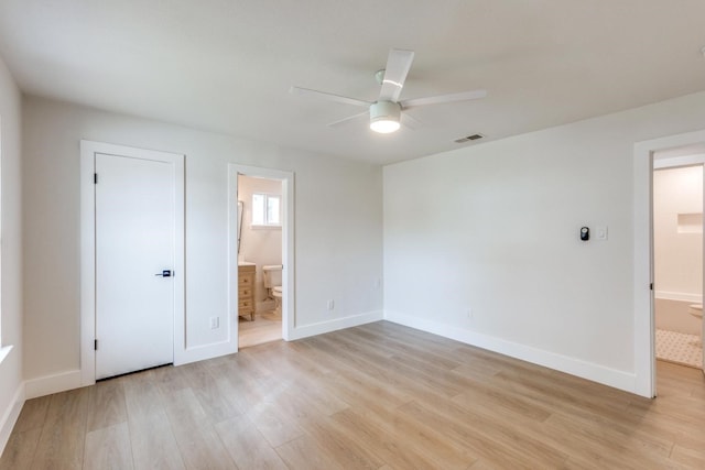 unfurnished bedroom featuring ensuite bathroom, light wood-type flooring, ceiling fan, and a closet