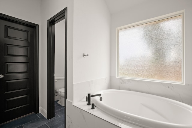 bathroom with toilet, tile patterned flooring, and a relaxing tiled tub