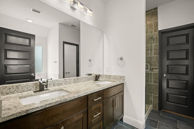 bathroom featuring a shower with door, tile patterned flooring, and vanity