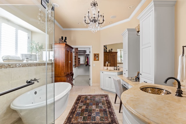 bathroom with ornamental molding, a bath, a chandelier, and vanity