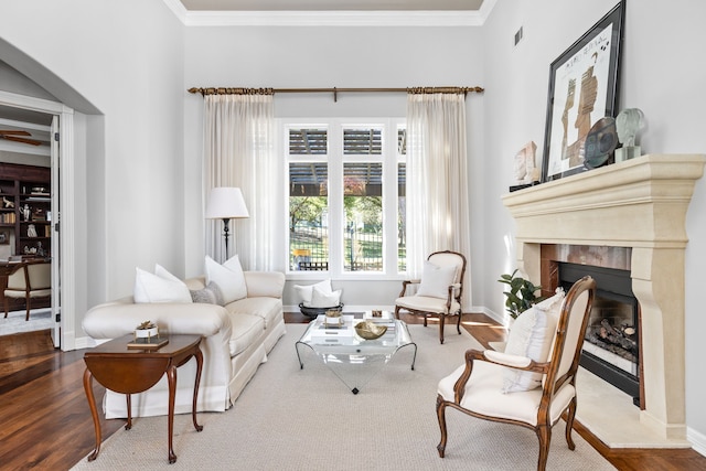 living area with crown molding and wood-type flooring