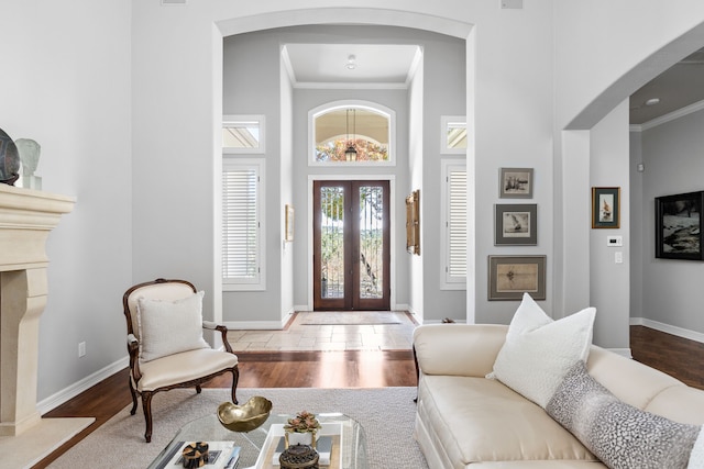 foyer entrance with french doors, crown molding, and wood-type flooring