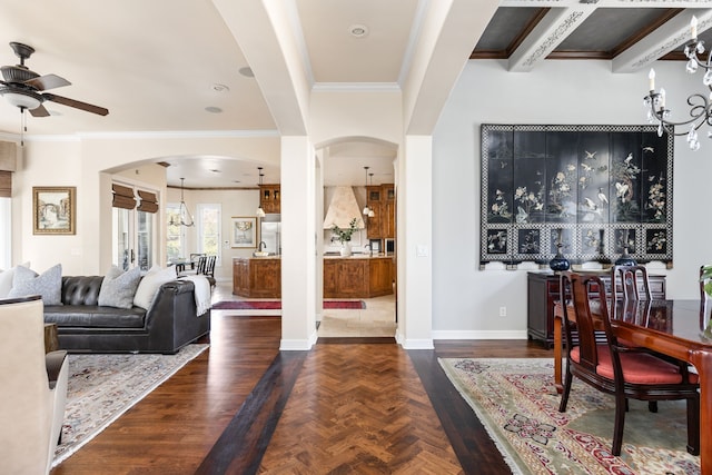 interior space featuring ceiling fan with notable chandelier, ornamental molding, and dark parquet floors