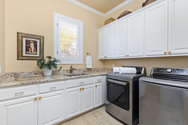 laundry room featuring sink, washing machine and dryer, ornamental molding, and cabinets