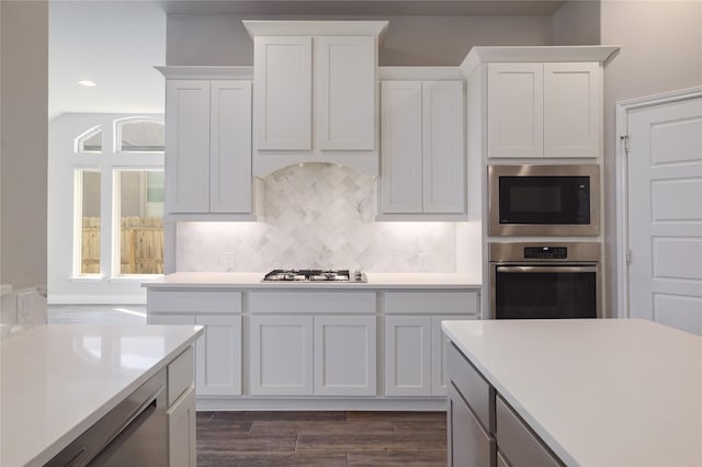 kitchen featuring stainless steel appliances, white cabinets, and dark hardwood / wood-style flooring