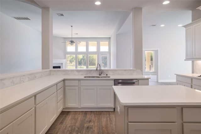 kitchen featuring dark wood-type flooring, a center island, ceiling fan, and sink