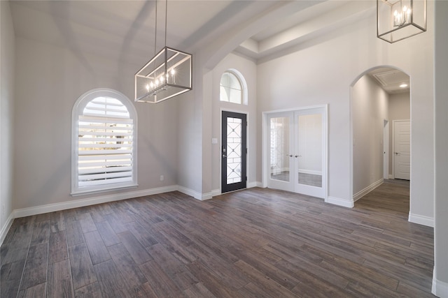 foyer entrance featuring a high ceiling, dark wood-type flooring, french doors, and a wealth of natural light