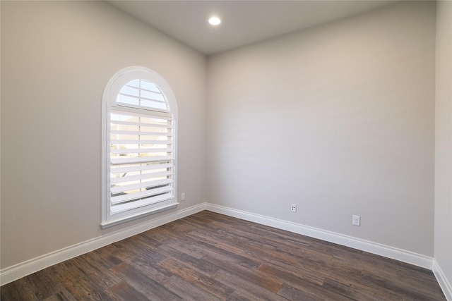 unfurnished room with dark wood-type flooring