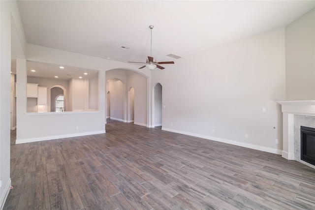 unfurnished living room featuring ceiling fan, a fireplace, and wood-type flooring