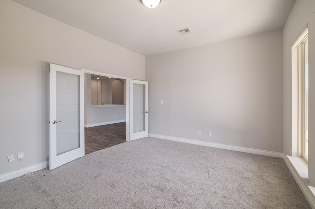 unfurnished bedroom with french doors and carpet flooring