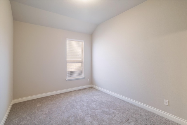 empty room with lofted ceiling and carpet