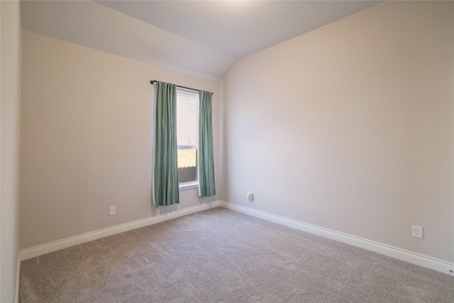 unfurnished room with light colored carpet and vaulted ceiling