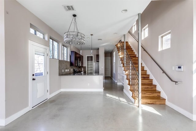 2912 E 14th St Unit A, Austin, TX 78702 - foyer featuring stairs, a chandelier, baseboards, and concrete flooring