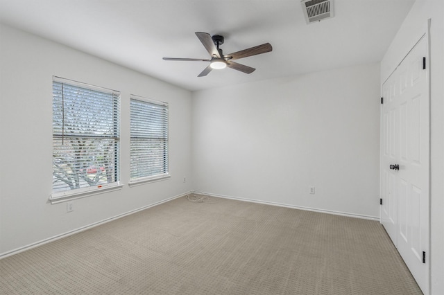 carpeted spare room with ceiling fan