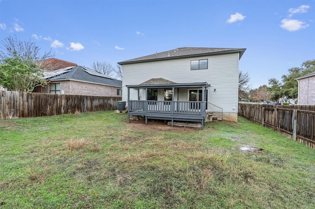 rear view of property featuring central AC unit, a wooden deck, and a lawn