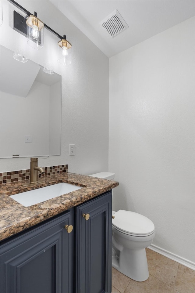 bathroom with tile patterned flooring, vanity, and toilet