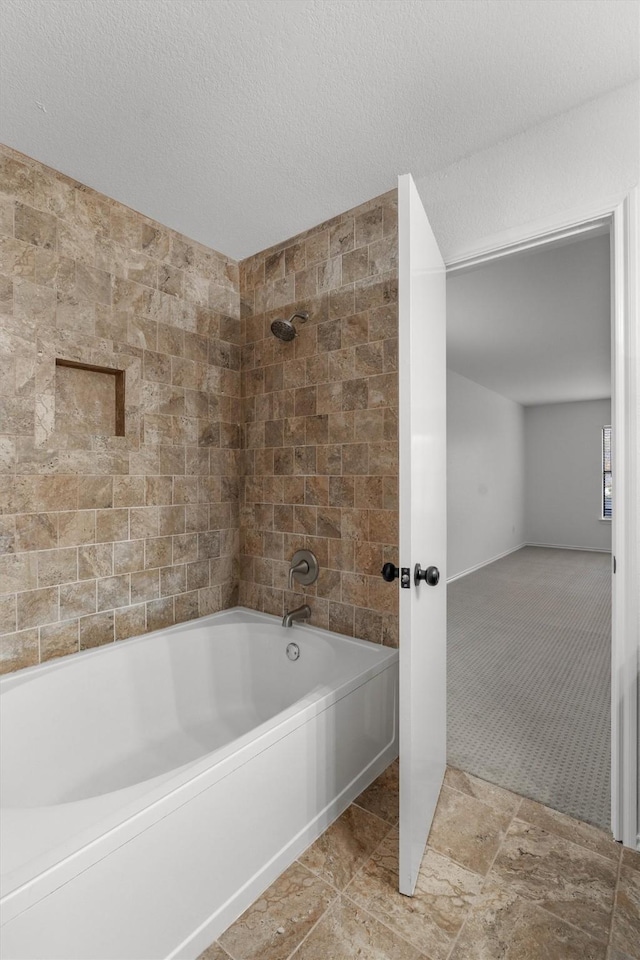 bathroom with a textured ceiling and shower / bath combination