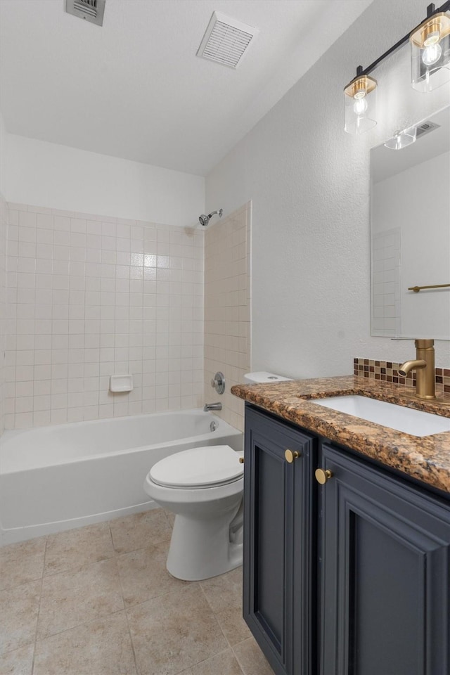 full bathroom featuring toilet, tiled shower / bath combo, tile patterned flooring, and vanity