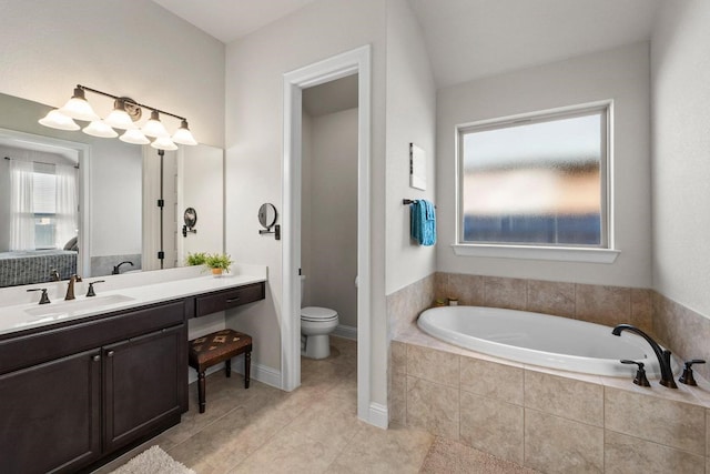 bathroom featuring toilet, tile patterned flooring, a relaxing tiled tub, and vanity