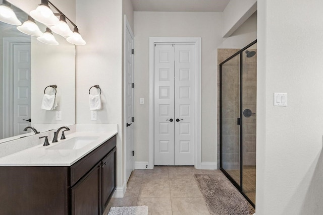 bathroom with a shower with door, tile patterned floors, and vanity