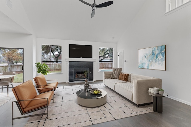 living room featuring a brick fireplace, high vaulted ceiling, ceiling fan, and hardwood / wood-style floors