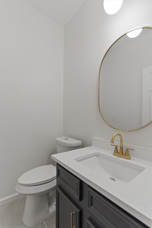 bathroom featuring toilet, vanity, and tile patterned flooring