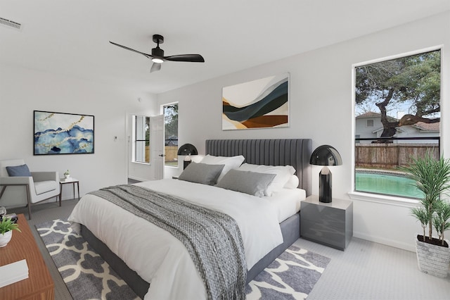 carpeted bedroom featuring ceiling fan and multiple windows