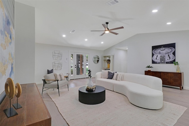 living room with vaulted ceiling, ceiling fan, light hardwood / wood-style floors, and french doors