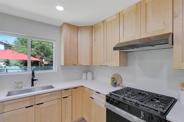 kitchen with under cabinet range hood, a sink, light countertops, light brown cabinetry, and gas stove