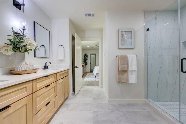 ensuite bathroom with double vanity, a marble finish shower, visible vents, connected bathroom, and a sink