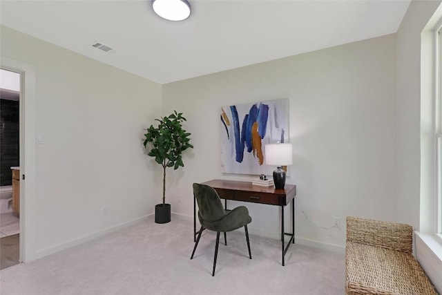 office space featuring light colored carpet, visible vents, and baseboards