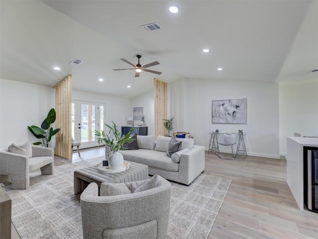 living area with vaulted ceiling, light wood-style flooring, visible vents, and recessed lighting