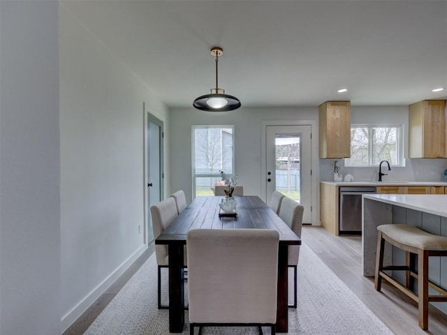 dining room with light wood finished floors, baseboards, and recessed lighting