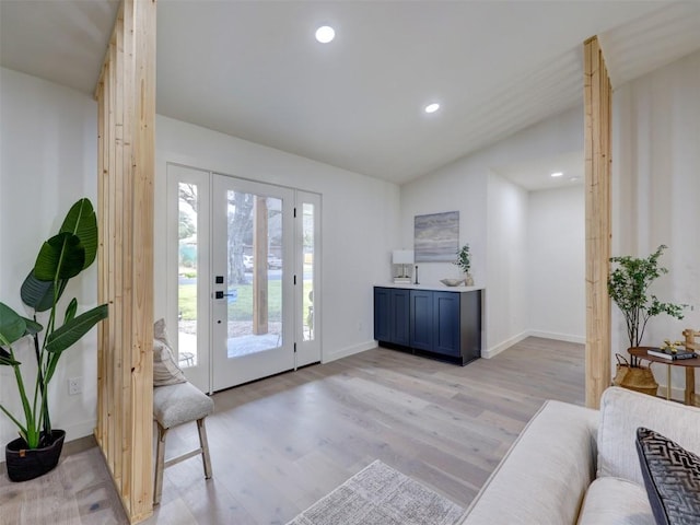 foyer with light wood-style floors, recessed lighting, vaulted ceiling, and baseboards